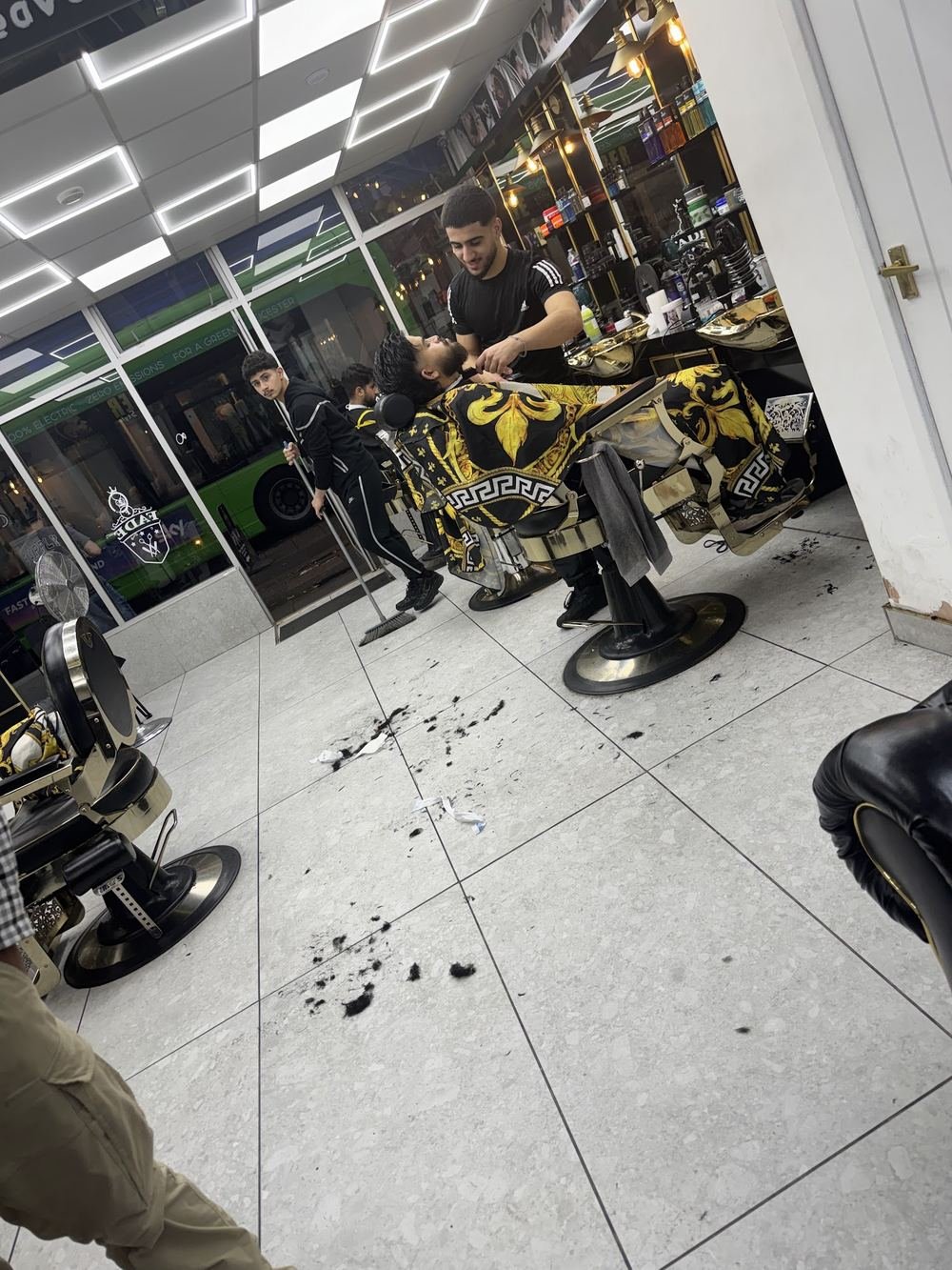 The shop floor with gold barber chairs and grey tiles